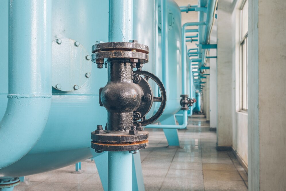 Industrial plumbing system featuring blue pipes and black valves, illustrating water management solutions relevant to sump pump and plumbing maintenance.